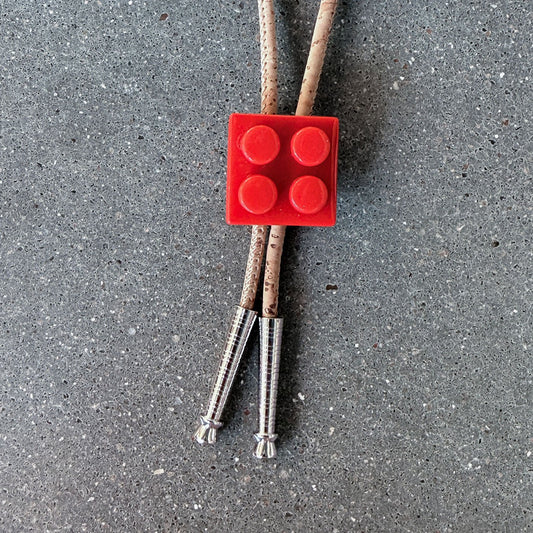 65b2bb63f348b87cbe1f70aa_clover-maven-11-glass-bolo-tie-red-lego-tan-cord-silver-tips_1784394017681.jpg