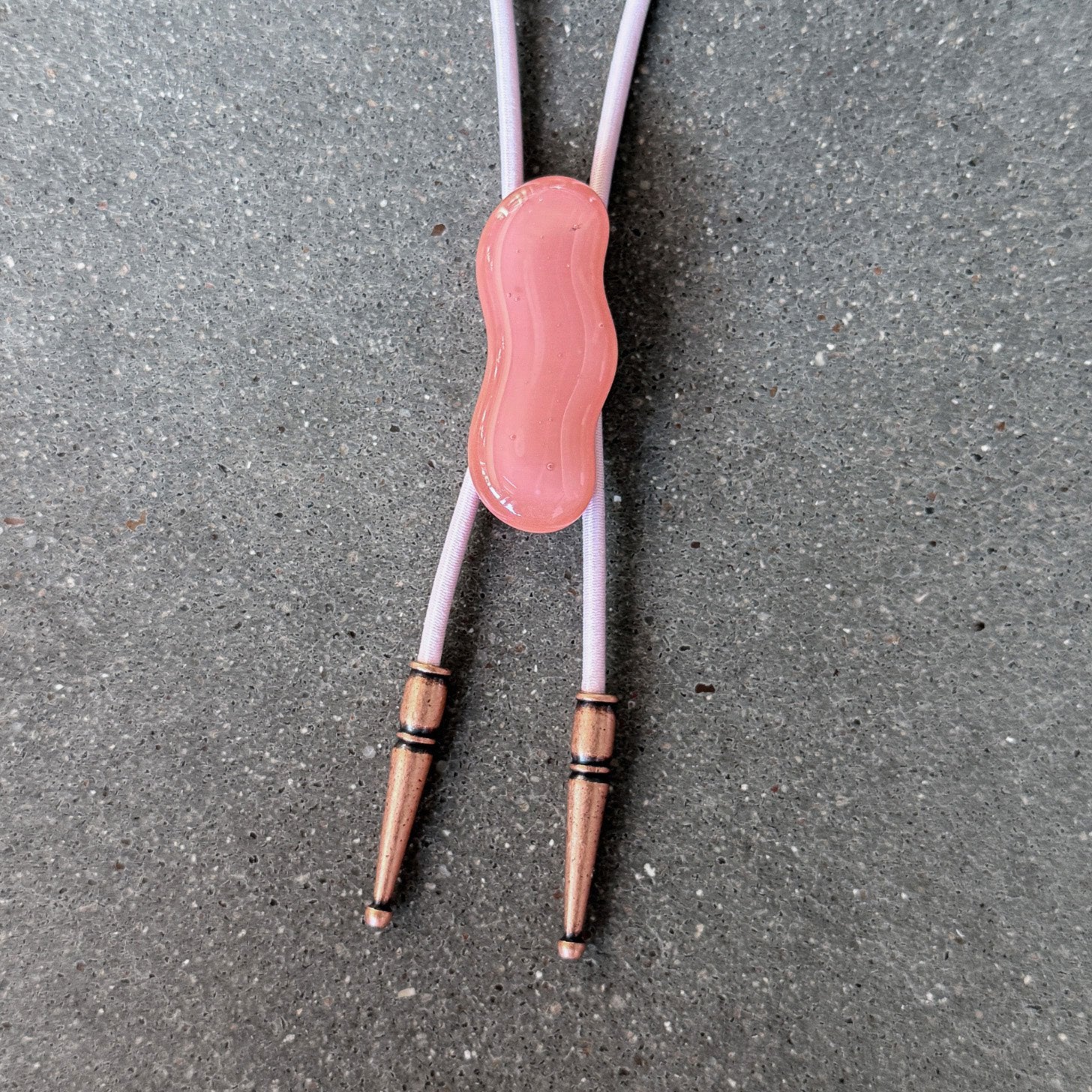 65b2bb63f348b87cbe1f70aa_clover-maven-12-glass-bolo-tie-pink-squiggle-pink-cord-copper-tips_1784383446924.jpg