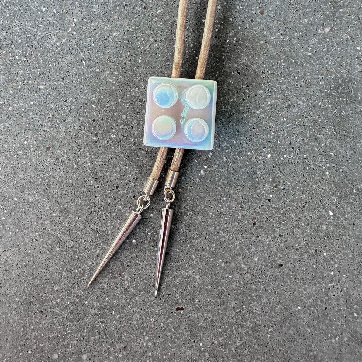 65b2bb63f348b87cbe1f70aa_clover-maven-18-glass-bolo-tie-white-lego-tan-cord-silver-tips_1784394017681.jpg