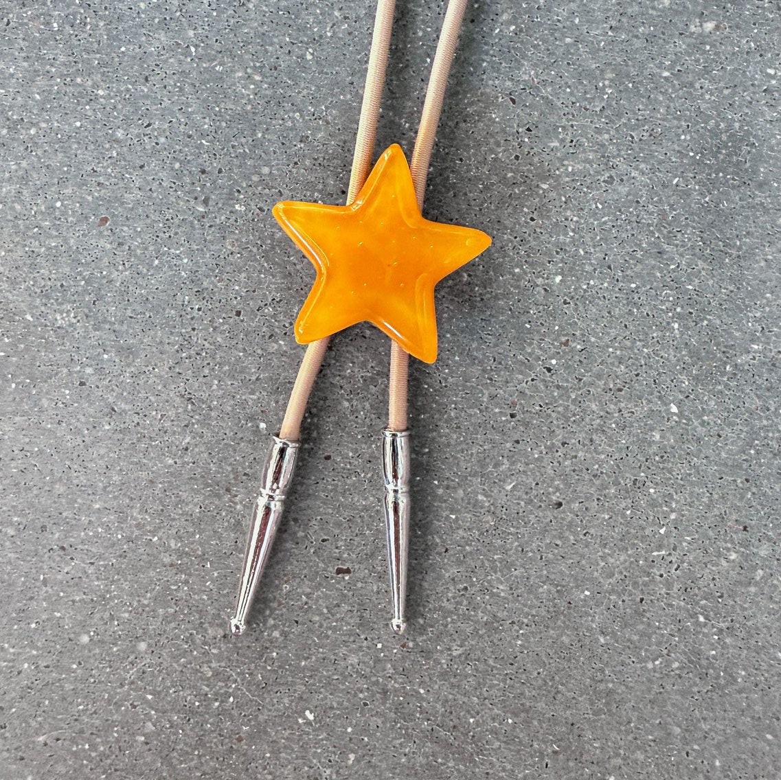 65b2bb63f348b87cbe1f70aa_clover-maven-19-glass-bolo-tie-yellow-star-tan-cord-silver-tips_1784383446924.jpg