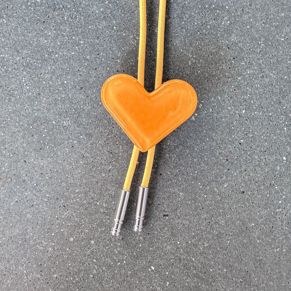 65b2bb63f348b87cbe1f70aa_clover-maven-21-glass-bolo-tie-yellow-heart-yellow-cord-silver-tips_1784383400049.jpg