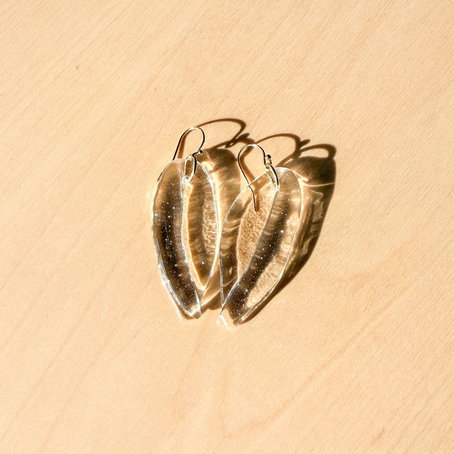65b2bb63f348b87cbe1f70aa_clover-maven-5-clear-glass-petal-earrings-2_1784396955199.jpg