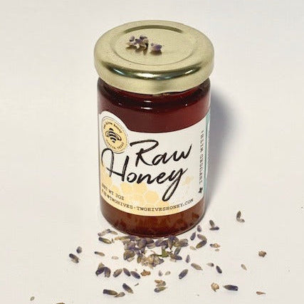 Jar of raw honey with lavender flowers on a white background